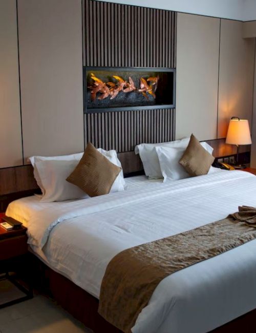 A cozy hotel room with a large bed, two side tables with lamps, and a wall-mounted decorative piece above the headboard.